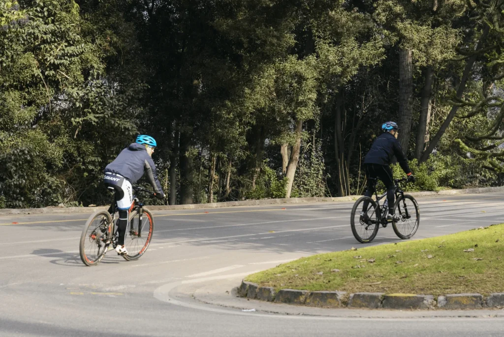 Descripción gráfica de dos personas andando en bicicleta como medio de movilización sostenible por una calle en Chile